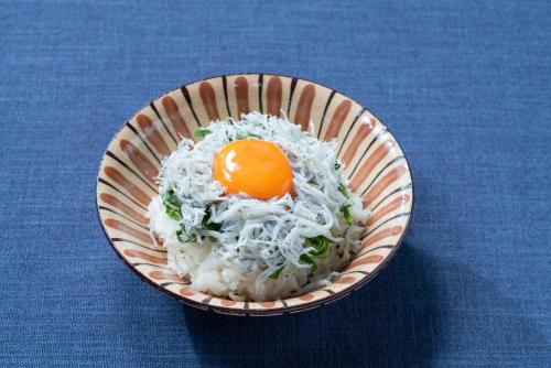a bowl of food with an egg on top of rice at Vessel Hotel Campana Nagoya in Nagoya
