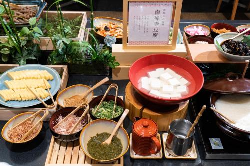 una mesa cubierta con tazones y platos de comida en Vessel Hotel Campana Kyoto Gojo, en Kioto