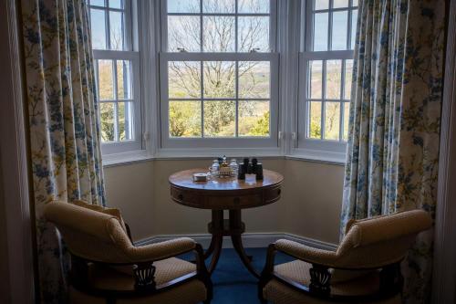 a room with a table and two chairs and a window at Kilmeny in Ballygrant