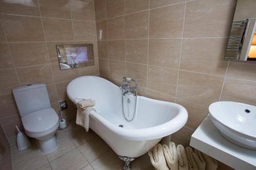 a bathroom with a tub and a toilet and a sink at Kilmeny in Ballygrant