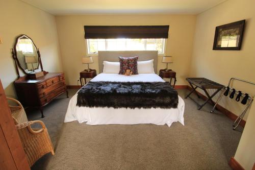 ein Schlafzimmer mit einem großen Bett und einem Spiegel in der Unterkunft Waipoua Lodge in Donnellys Crossing