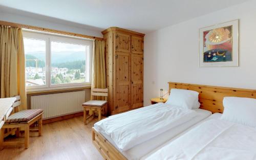 Un dormitorio con dos camas y una ventana. en Ova Cotschna 705, en St. Moritz