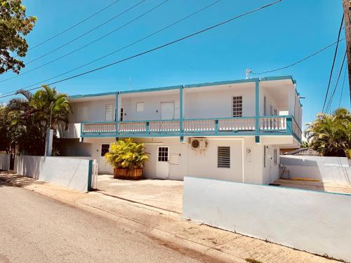 Casa blanca con balcón en una calle en Coastal Express Inn & Suites #1 at 681 Ocean Drive, en Arecibo