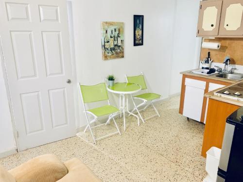 a kitchen with a table and chairs in a kitchen at Atenas City Inn in Manati