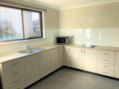 a kitchen with a sink and a microwave at Bathurst Motor Inn in Bathurst