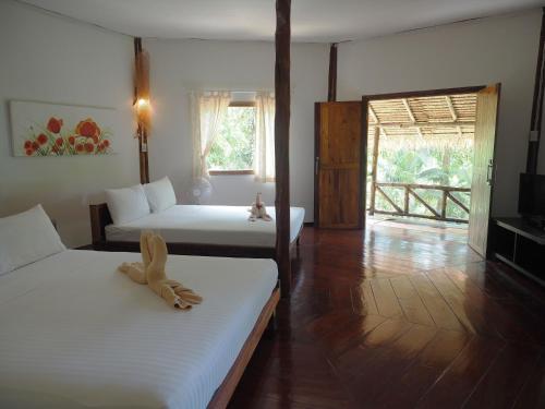 a hotel room with two beds and a balcony at LITTLE EDEN Bungalows in Ko Chang