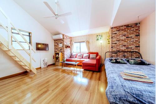 - une chambre avec un lit et un mur en briques dans l'établissement nestay house tokyo itabashi 02, à Tokyo