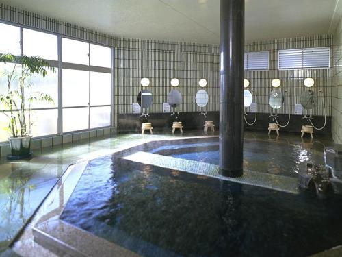 a swimming pool in a building with a large room with a pool at Shouheikaku in Matsue