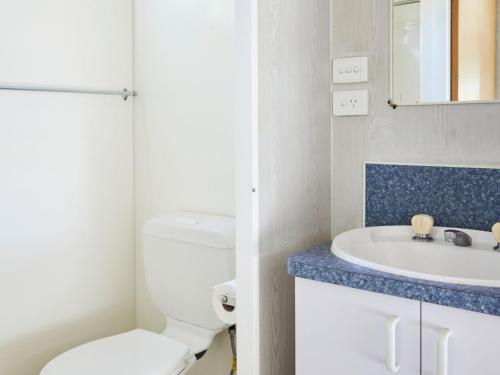 La salle de bains est pourvue de toilettes blanches et d'un lavabo. dans l'établissement Horseshoe Bay Holiday Park, à South West Rocks