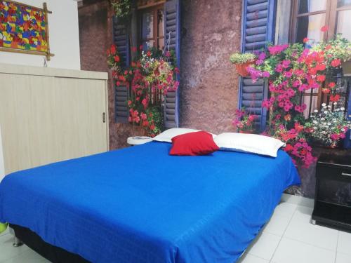 a blue bed with red and white pillows on it at APARTA ESTUDIO 7051 in Medellín