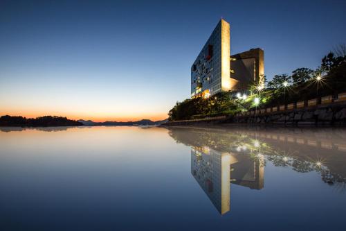 a building on a lake at night at Hidden Bay Hotel in Yeosu