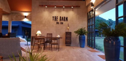 a dining room with a table and a sign on the wall at The Barn Hua Hin in Khao Tao