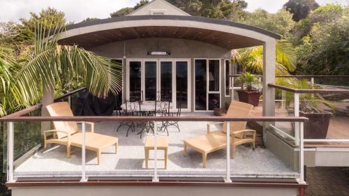 a gazebo on a house with chairs and a table at Sanctuary Palms in Paihia