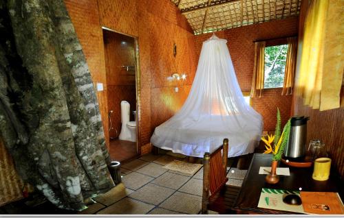 a room with a bathroom with a toilet and a table at Vythiri Resort in Vythiri