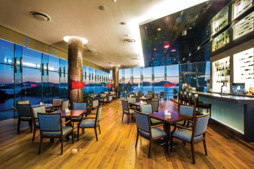 a restaurant with tables and chairs and a bar at Hidden Bay Hotel in Yeosu