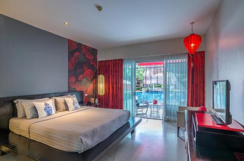 1 dormitorio con cama, escritorio y ventana en Red Ginger Chic Resort - SHA Extra Plus, en Ao Nang Beach