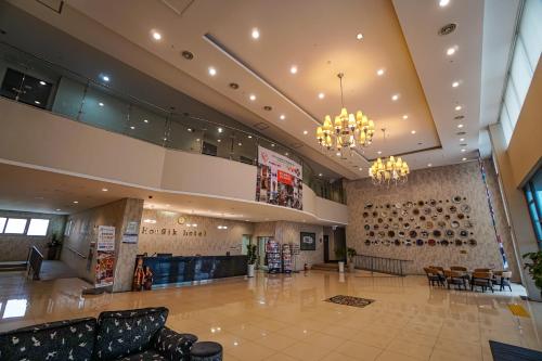 a large lobby with chairs and tables in a building at Hi Jeju Hotel in Jeju