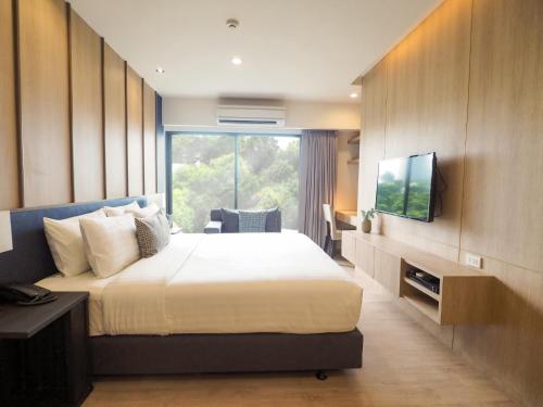 a hotel room with a bed and a tv at The Residence on Thonglor by UHG in Bangkok