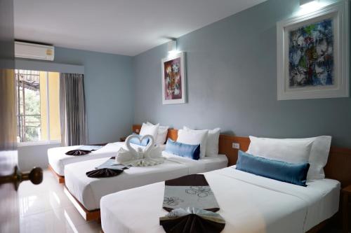 a hotel room with three beds with blue walls at Villa Cha-Cha Khaosan Rambuttri in Bangkok