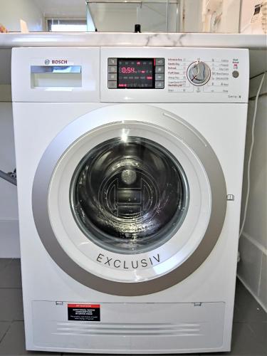 a white washing machine sitting in a room at Hi 5 Glenelg Studio Apartment in Glenelg