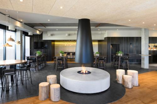 a lobby with a table and some tables and chairs at Little National Hotel Canberra in Canberra