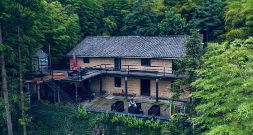 ein Haus mitten im Wald in der Unterkunft Prodigy Hostel Mogan Mountain in Deqing