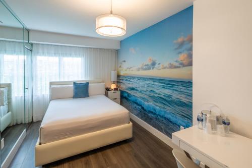 a bedroom with a bed and a painting of the ocean at President Hotel in Miami Beach