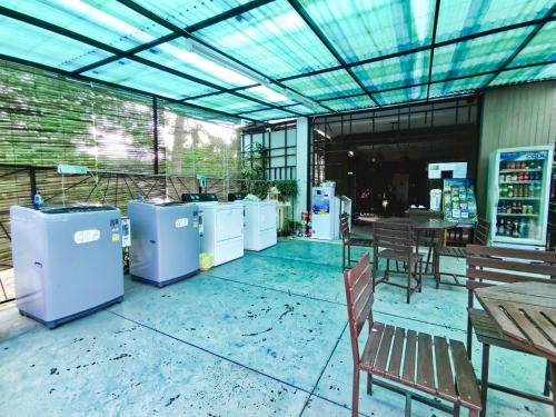 a patio with several washers and dryers and a table and chairs at Tree Boutique Residence - Quiet Oasis - Stunning View, Pool & Gym in Chiang Mai