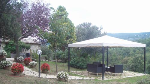 a table and chairs under an umbrella in a garden at Agriturismo Castello Di Belforte in Todi