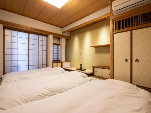 nid OSAKA Atre Nakatsu في أوساكا: سريرين في غرفة بها نافذة