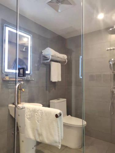 a bathroom with a toilet and a glass shower at Qinfu Hotel Beijing Nanluogu Lane Houhai in Beijing