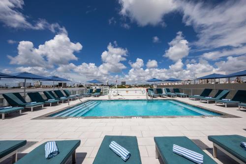 a pool with chaise lounge chairs at President Hotel in Miami Beach