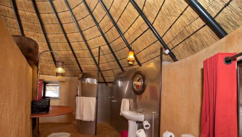 a bathroom with a toilet and a sink at Ongula Village Homestead Lodge in Omupumba