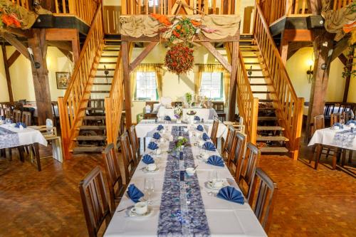 a dining room with a long table in a room with stairs at Pension Kräutermühlenhof Burg in Burg