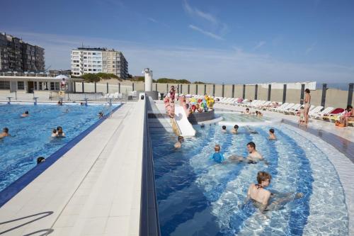 - un groupe de personnes dans une piscine sur une plage dans l'établissement Zeedijk Oostduinkerke frontaal zeezicht - volledig gerenoveerd 2022!, à Oostduinkerke