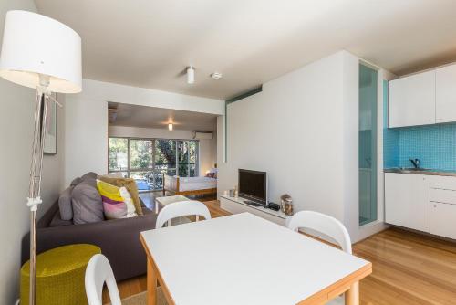 
a living room filled with furniture and a tv at Cottesloe Tree Top Studio in Perth

