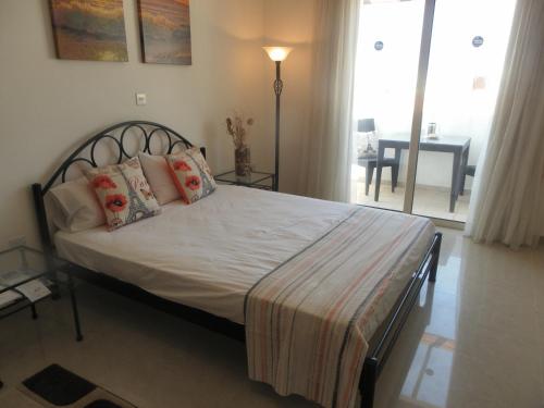 um quarto com uma cama grande e almofadas em Studio, E104 with double bed, kitchen & shower room, sunny balcony em Pegeia ou Pegya