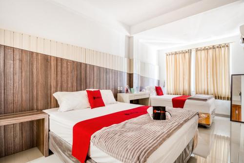 ein Hotelzimmer mit 2 Betten mit roten Akzenten in der Unterkunft RedDoorz near UNTAG Surabaya in Surabaya