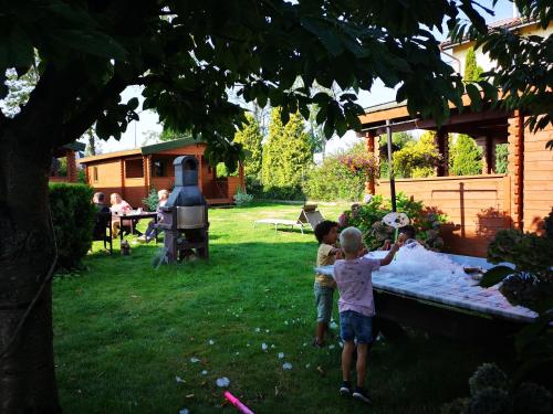 dos niños jugando en un patio trasero con piscina en Szyper pokoje i domki, en Władysławowo