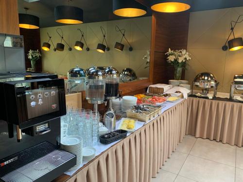 a buffet line with food and dishes on a table at Hotel Santa Monica in Mikołajki