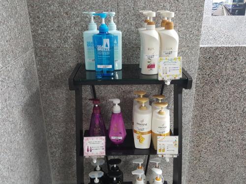 a shelf with a bunch of bottles on it at Hotel Hokke Club Shonan Fujisawa in Fujisawa