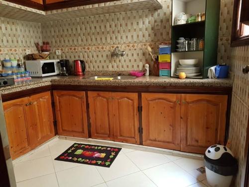 uma cozinha com armários de madeira e um tapete de cozinha no chão em Zwina Appart: A Small, Cozy Family Nest em Marrakech