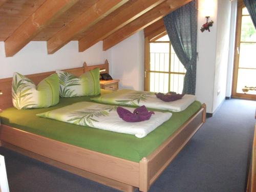 a bedroom with two beds with green pillows at Ferienwohnung Himmelsgaube in Oberjoch
