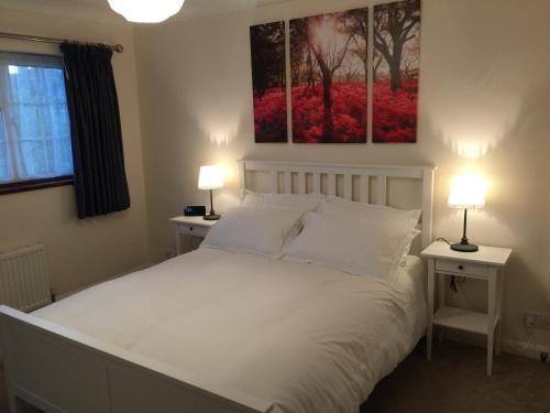 a bedroom with a white bed with two night stands at New Forest Brockenhurst in Brockenhurst