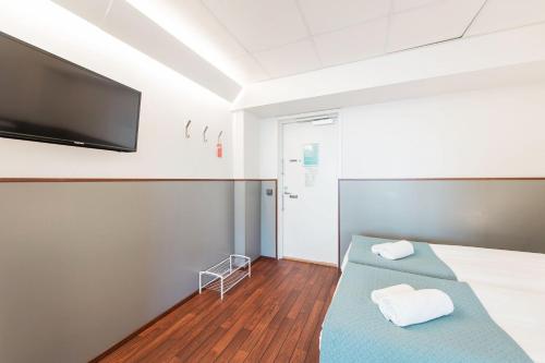a hospital room with two beds and a flat screen tv at Forenom Aparthotel Helsinki Kamppi - contactless check-in in Helsinki