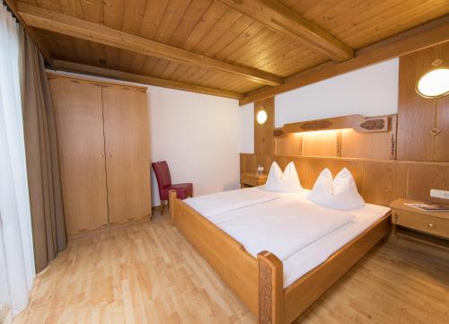 a bedroom with a bed and a wooden ceiling at Appartementhaus Toni inklusive Zell am See - Kaprun Sommerkarte in Kaprun