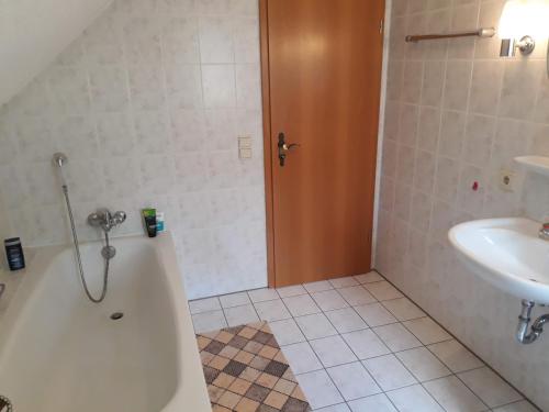 巴特薩羅的住宿－Ferienwohnung direkt am See，带浴缸和盥洗盆的浴室