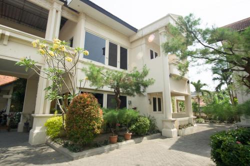 a large white building with plants in front of it at RedDoorz near Rumah Sakit Baptis Kediri in Kediri