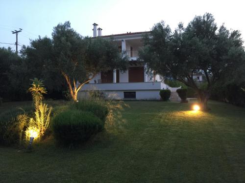 ein Haus in einem Hof mit zwei Lichtern im Gras in der Unterkunft CASA DI MADI in Chalkida