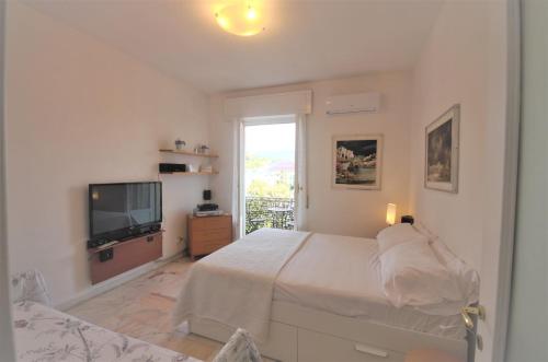 a white bedroom with a bed and a television at Holiday Home Santa Margherita Ligure in Santa Margherita Ligure